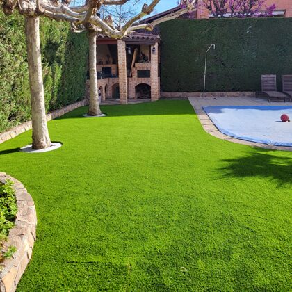 Jardin con césped artificial alredodor piscina en Rivas