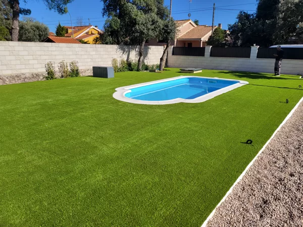 Jardin con césped artificial en  Eurovillas alrededor de la piscina