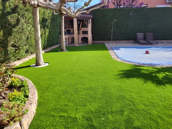 Jardin con césped artificial alredodor piscina en Rivas
